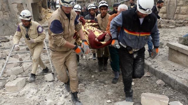 انقاذ امرأة مسنة من تحت الانقاض بعد غارة للنظام في حلب (AFP)