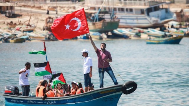 فلسطينيون يرفعون العلم التركي والفلسطيني في الذكرى الخامسة لأحداث أسطول المرمرة (Aaed Tayeh/Flash90)