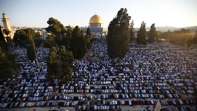 رجال فلسطينيون يُصلون صلاة العيد في الأقصى (AFP)