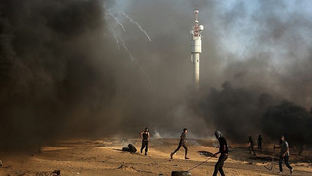 فلسطينيون يحرقون إطارات مطاطية عند السياج الحدودي بين قطاع غزة وإسرائيل (Abed Rahim Khatib/ Flash90)