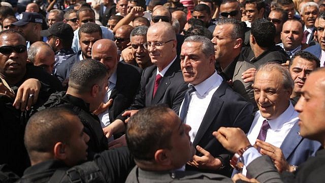 الوزير حسين الشيخ عن يمين رئيس الوزراء الفلسطيني رامي الحمدلله (AFP)